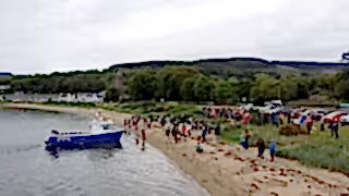 People on the beach at a boat launch.