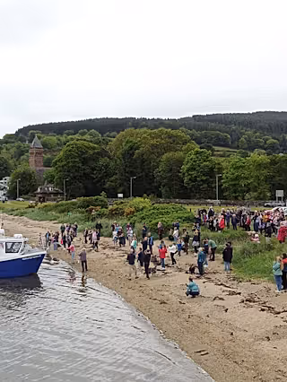 People on the beach at a boat launch.