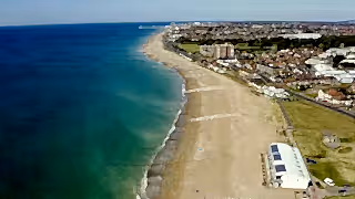 Aerial view of Sussex Bay showing the coastline, with ocean, sandy beach, and surrounding coastal landscape visible from above.